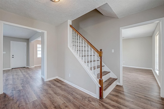 stairway featuring wood-type flooring and a textured ceiling