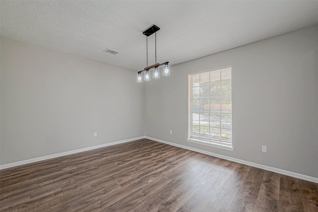 unfurnished room featuring dark hardwood / wood-style flooring and a textured ceiling