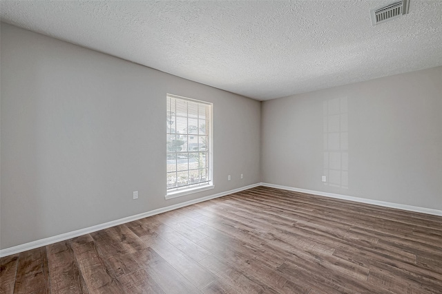 empty room featuring hardwood / wood-style floors and a textured ceiling