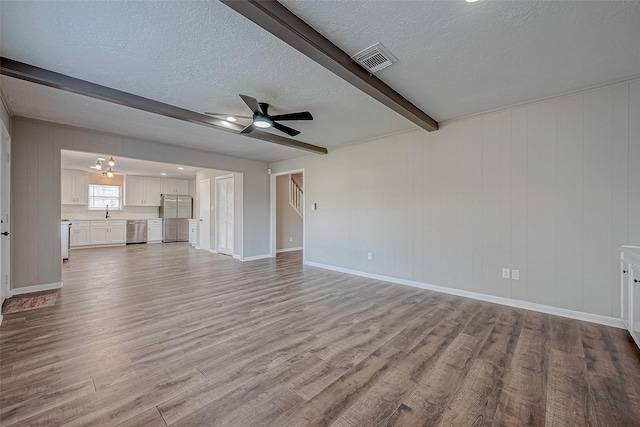 unfurnished living room with beam ceiling, sink, light hardwood / wood-style floors, a textured ceiling, and ceiling fan with notable chandelier