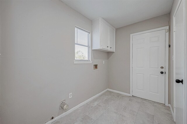 clothes washing area with washer hookup and cabinets