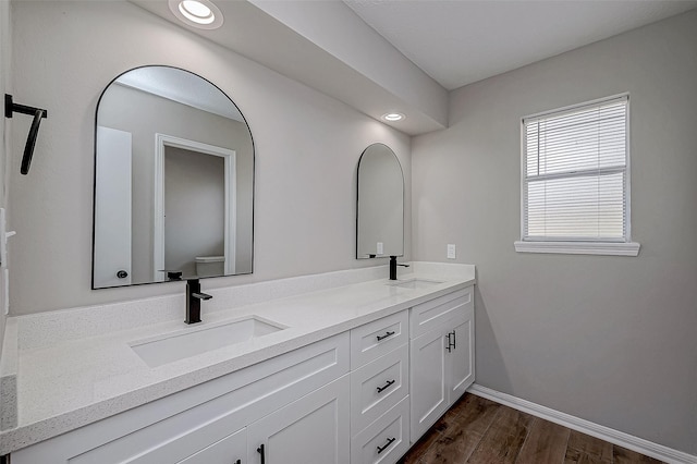 bathroom featuring wood-type flooring, vanity, and toilet