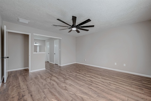 spare room featuring a textured ceiling, light hardwood / wood-style flooring, and ceiling fan