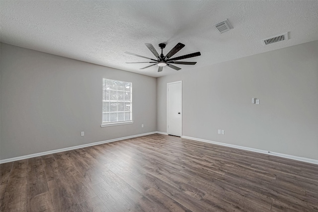 spare room with a textured ceiling, ceiling fan, and dark wood-type flooring