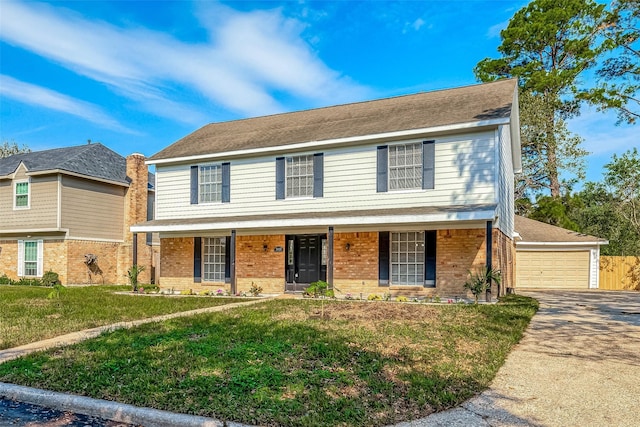 view of front of house with a porch, a garage, and a front lawn