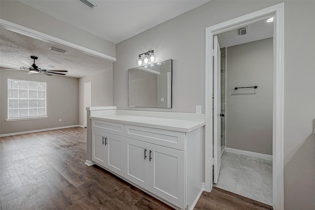 bathroom with ceiling fan, vanity, a textured ceiling, and hardwood / wood-style flooring