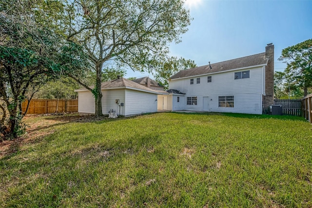 rear view of house featuring a yard and central air condition unit