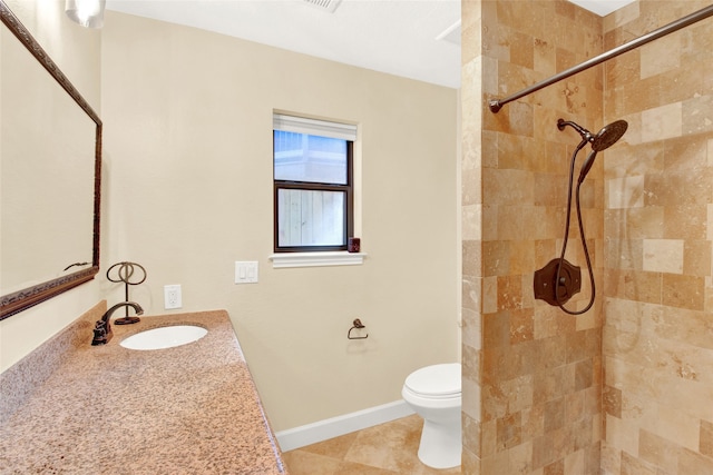 bathroom featuring a tile shower, vanity, toilet, and tile patterned floors