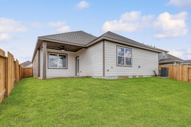 back of property with central AC unit, ceiling fan, and a lawn