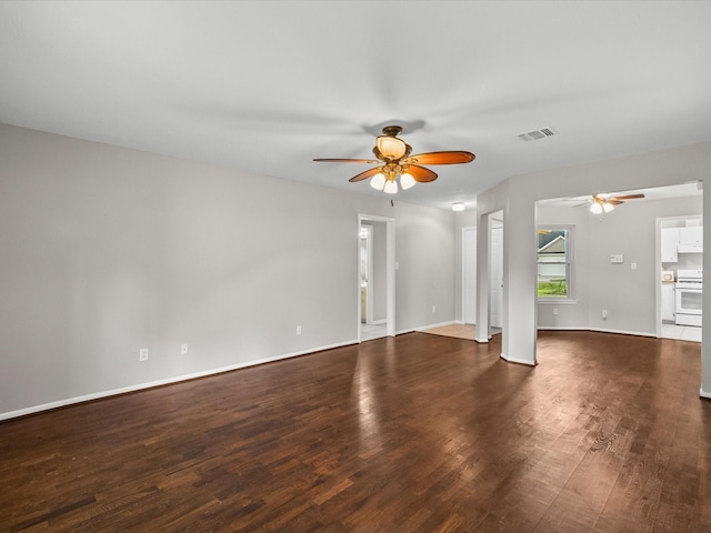 unfurnished living room with dark hardwood / wood-style flooring and ceiling fan