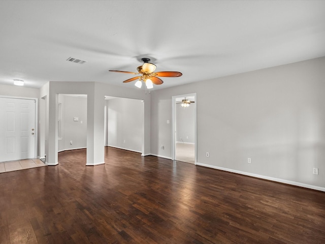 empty room with ceiling fan and dark hardwood / wood-style flooring