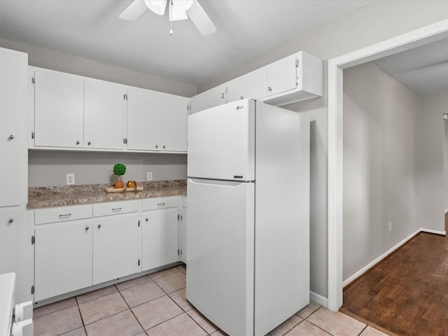 kitchen with ceiling fan, white refrigerator, light tile patterned flooring, and white cabinetry