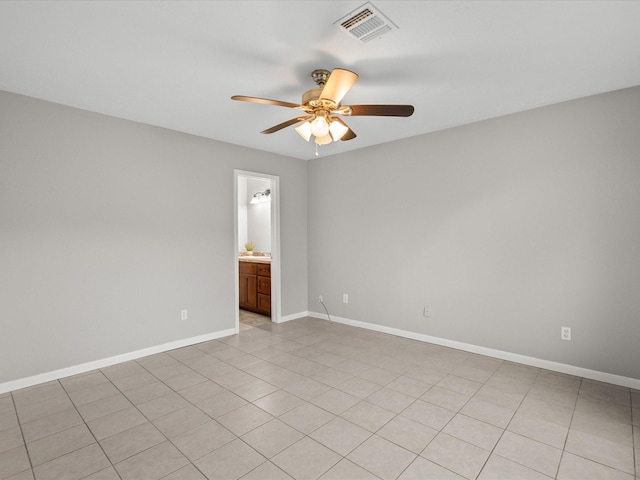 spare room with ceiling fan and light tile patterned floors