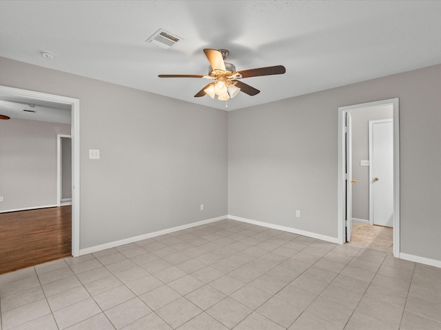 tiled spare room featuring ceiling fan