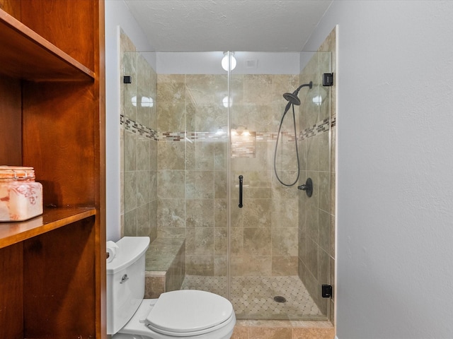 bathroom featuring a shower with shower door, a textured ceiling, and toilet