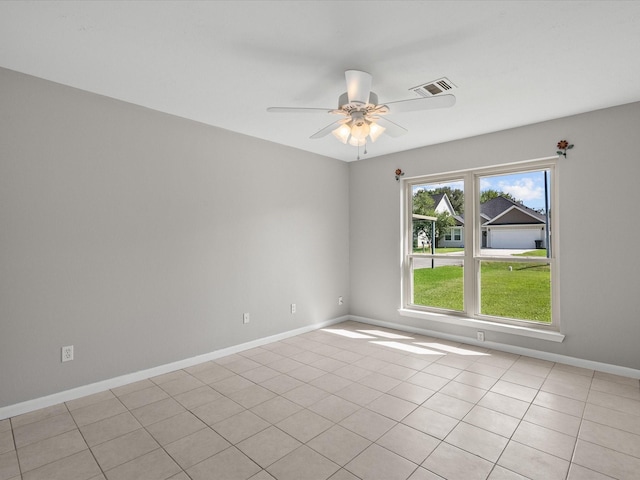 tiled spare room with ceiling fan