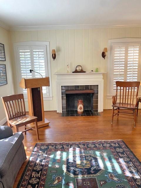 living area featuring hardwood / wood-style flooring, crown molding, and a fireplace