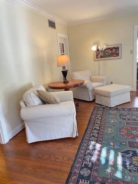 living room with dark hardwood / wood-style floors and crown molding