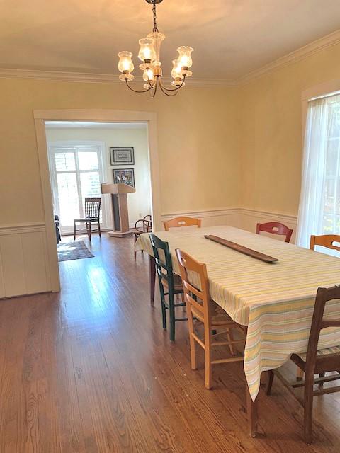 dining room featuring a chandelier, crown molding, and dark wood-type flooring