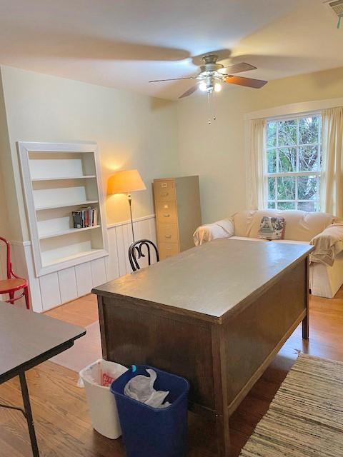 office with built in shelves, hardwood / wood-style flooring, and ceiling fan