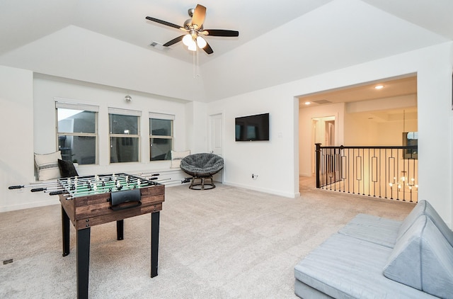 recreation room with ceiling fan, vaulted ceiling, carpet floors, and a tray ceiling