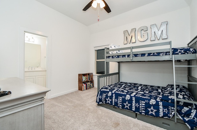 bedroom with sink, light colored carpet, ceiling fan, and ensuite bathroom