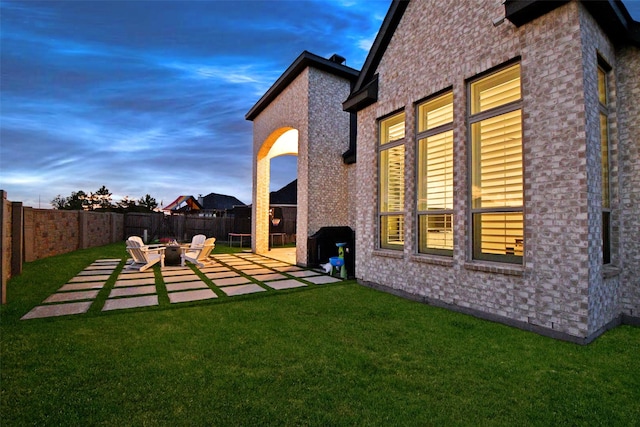 yard at dusk featuring a patio area and an outdoor fire pit