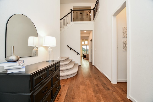 hallway featuring a towering ceiling and hardwood / wood-style flooring