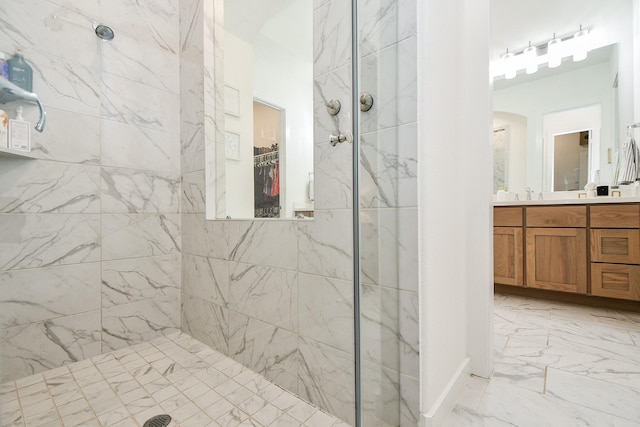 bathroom with a tile shower and vanity