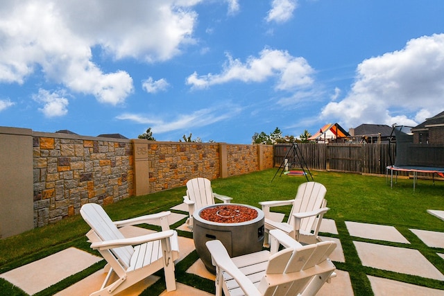 view of patio / terrace featuring an outdoor fire pit and a trampoline