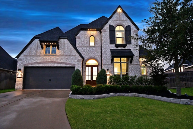 view of front of home featuring a garage, a yard, and french doors