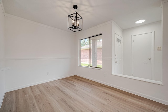 entrance foyer featuring a chandelier, light wood-type flooring, and ornamental molding