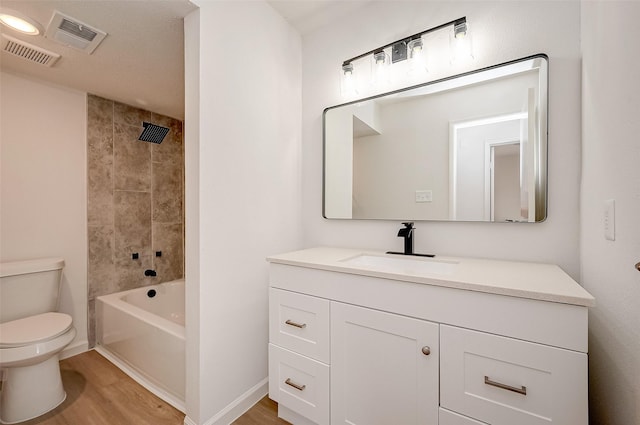 full bathroom featuring wood-type flooring, vanity, toilet, and tiled shower / bath