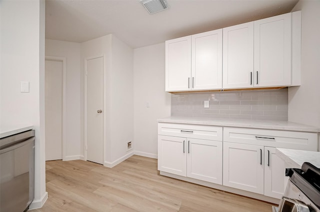 kitchen with tasteful backsplash, white cabinetry, stainless steel range, and light hardwood / wood-style flooring