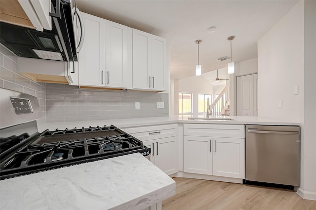 kitchen with decorative backsplash, white cabinetry, ceiling fan, and stainless steel dishwasher