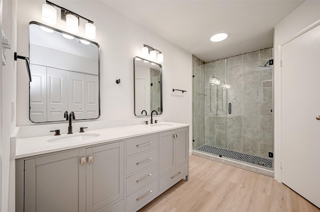 bathroom featuring hardwood / wood-style flooring, vanity, and a shower with door