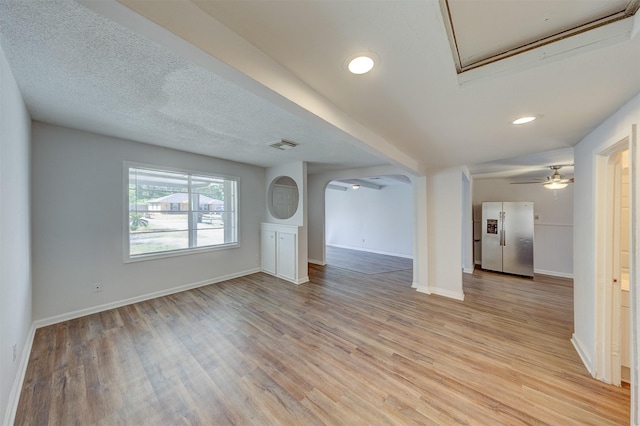 unfurnished living room featuring light hardwood / wood-style floors and ceiling fan