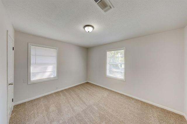 carpeted spare room with a textured ceiling