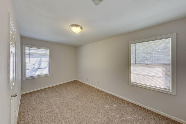 carpeted spare room with a healthy amount of sunlight