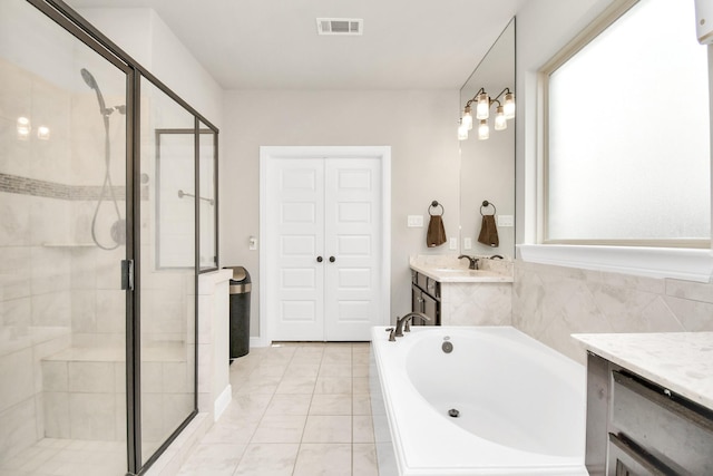 bathroom featuring vanity, tile patterned flooring, and plus walk in shower