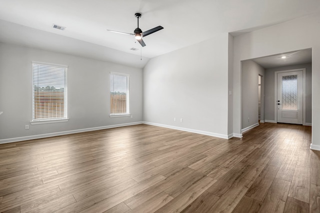 empty room with wood-type flooring, ceiling fan, and lofted ceiling