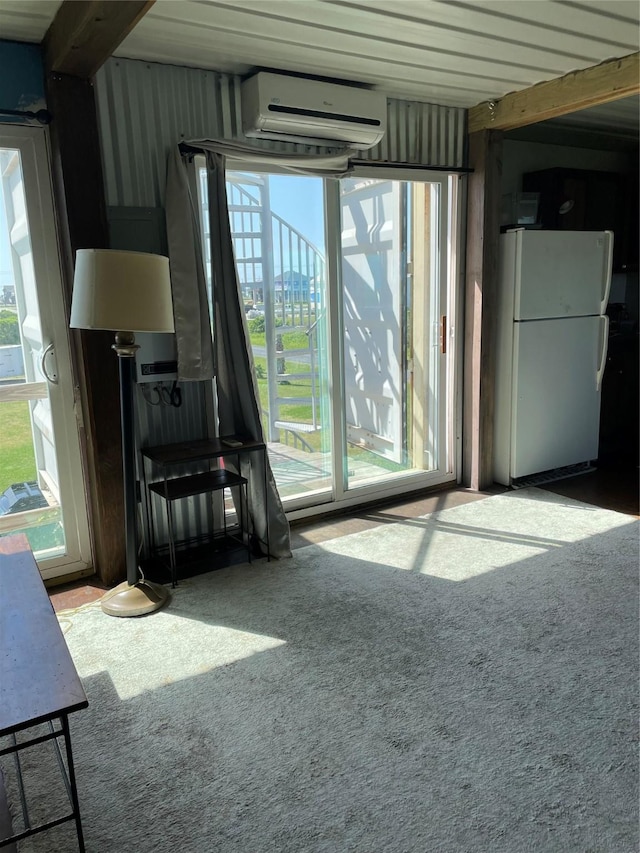 interior space featuring plenty of natural light, beamed ceiling, and a wall mounted air conditioner