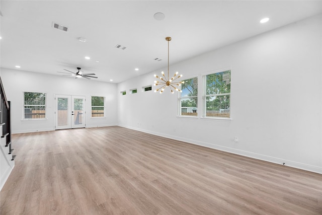 interior space featuring ceiling fan with notable chandelier, french doors, and light hardwood / wood-style flooring