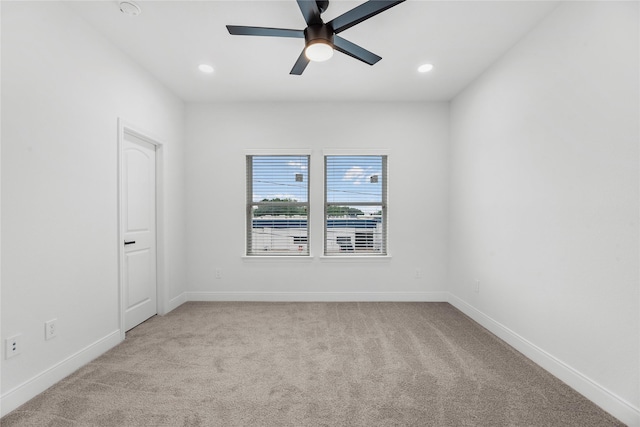 spare room with ceiling fan and light carpet