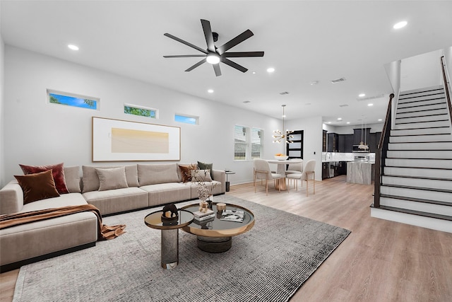 living room with light wood-type flooring and ceiling fan