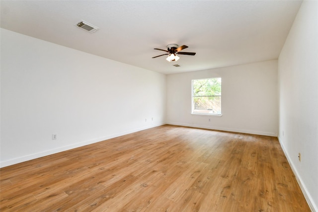 empty room with ceiling fan and light hardwood / wood-style flooring