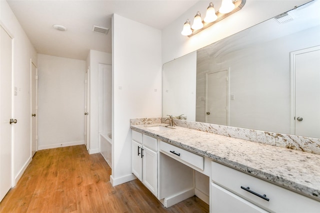 bathroom featuring hardwood / wood-style floors, vanity, and shower / bath combination