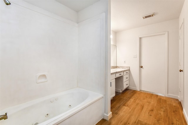 bathroom featuring a washtub, vanity, and hardwood / wood-style flooring