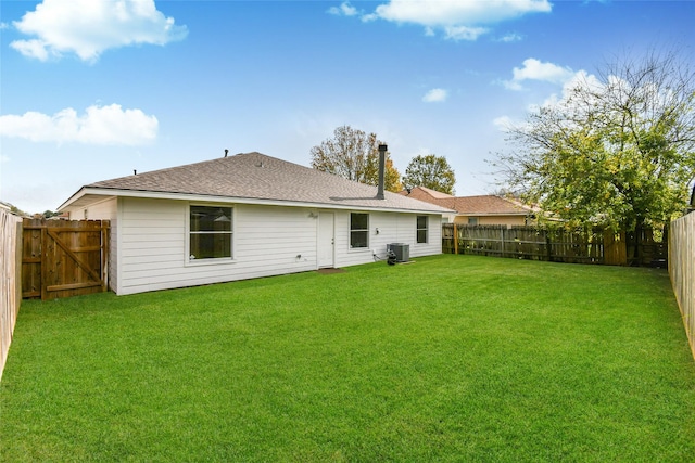 rear view of property featuring a yard and cooling unit