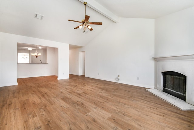 unfurnished living room featuring ceiling fan with notable chandelier, beam ceiling, wood-type flooring, and high vaulted ceiling